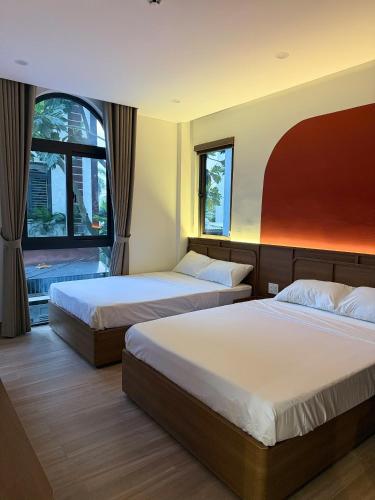 a hotel room with two beds and a window at Airport Homestay 2 in Danang