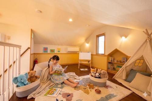 a little girl sitting on the floor in a play room at KANEAGE BASE 14名までokの大型一棟貸し 家族旅行 合宿遠征 長期滞在に 海浜公園大洗20分 in Hitachinaka