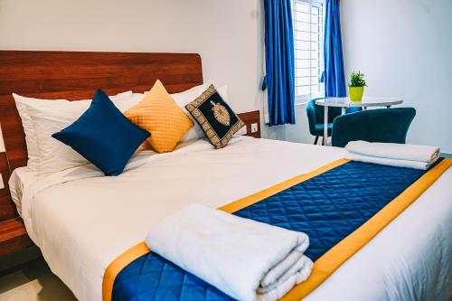 a hotel room with a bed with towels on it at Keerthis Elite Hotel near Kempegowda international airport in Bangalore