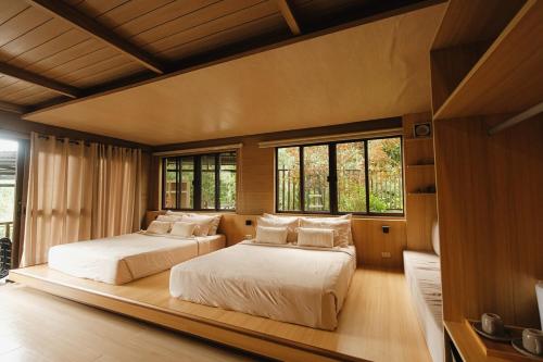two beds in a large room with windows at 150 Peakway Mountain Resort in Dalaguete