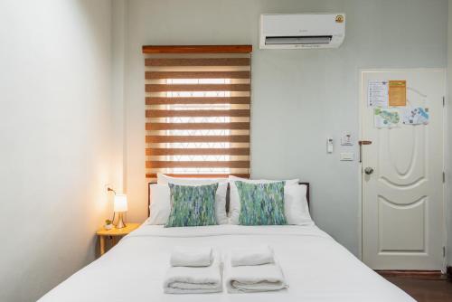 a bedroom with a large white bed with two pillows at An Ant House in Bangkok