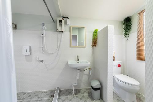 a bathroom with a toilet and a sink at An Ant House in Bangkok