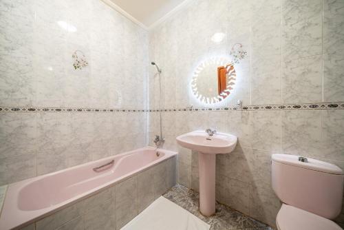 a bathroom with a sink and a tub and a toilet at Spacious Apartment 1 min from Beach in Tangier