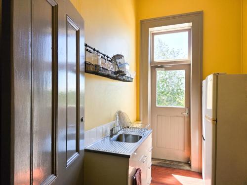 a kitchen with a sink and a refrigerator at Cessnock Hotel Hunter Valley in Cessnock