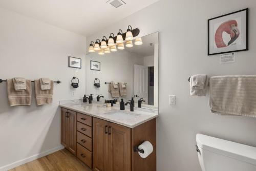 a bathroom with a sink and a toilet and a mirror at The Elevated Gallery - Historic Loft - Heart of Downtown - 98WalkScore in Denver