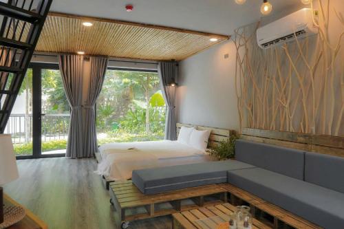 a bedroom with a bed and a large window at Babylon Mini Resort in Vung Tau