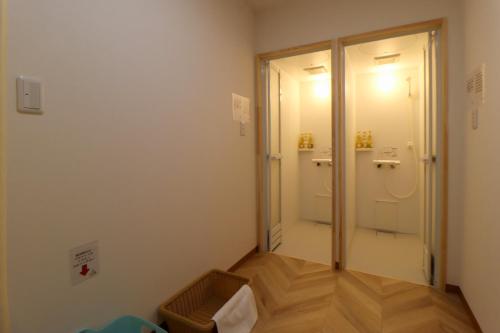 a room with a walk in shower and a glass door at たっこ宿 in Takko