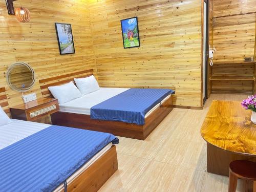 a room with two beds in a wooden cabin at Huy Hùng Cô Tô in Nam Cap