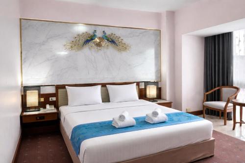ein Hotelzimmer mit einem Bett, auf dem Handtücher liegen in der Unterkunft Asian Hotel in Hat Yai