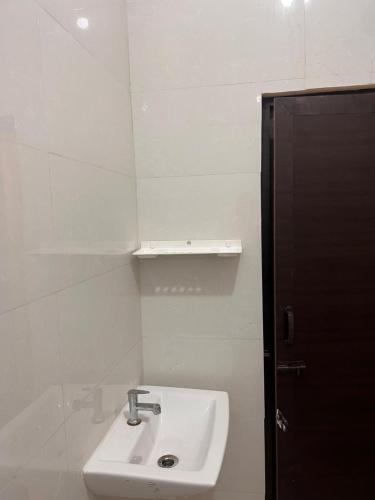a white bathroom with a sink and a mirror at Du Auro Residency in Kuilapayam