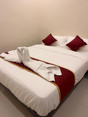 two beds with red and white blankets and pillows at Du Auro Residency in Kuilapayam