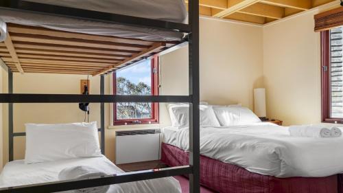 two bunk beds in a room with a window at Gundanora Chalet in Mount Hotham