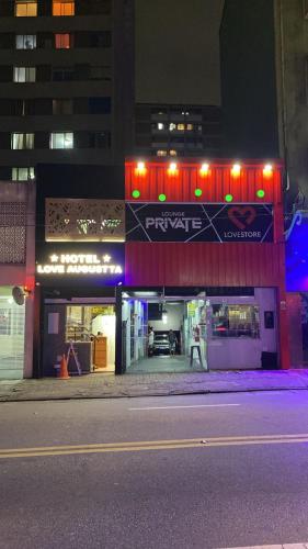a store with a sign on the front of it at night at Hotel Love Augustta in São Paulo