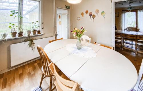 a white table with a vase of flowers on it at 2 Bedroom Nice Home In Glömminge in Glömminge