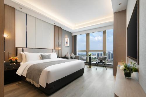 a bedroom with a large bed and a large window at Grand Madison Hotel Hangzhou in Hangzhou