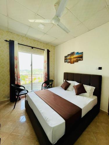 a bedroom with a large bed and a large window at Villa Avora Ridge in Kandy