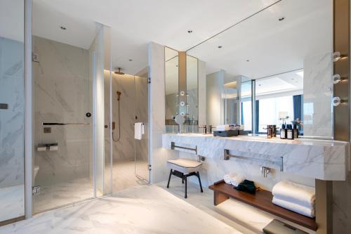 a bathroom with a shower and a sink and a mirror at Grand Madison Hotel Hangzhou in Hangzhou