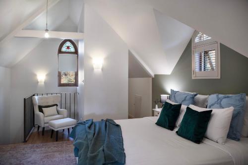 a bedroom with a large bed and a chair at El Camino in Hepburn Springs