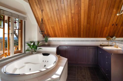 a large bathroom with a tub and a sink at El Camino in Hepburn Springs