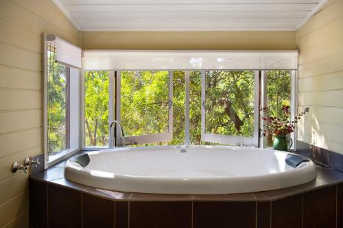 a large tub in a bathroom with a window at Avalon in Hepburn Springs