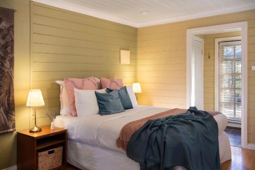 a bedroom with a large bed with pink and blue pillows at Avalon in Hepburn Springs