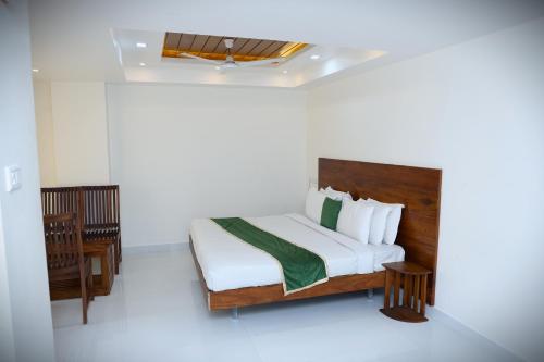 a bedroom with a bed and a chair in it at Delano Residency in Kaliyal