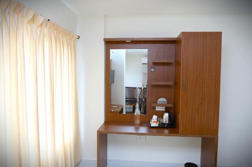a room with a mirror and a wooden cabinet at Delano Residency in Kaliyal