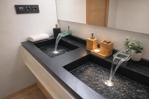 a bathroom with a black sink with two faucets at Casa Solaria Córdoba in Guadalcázar