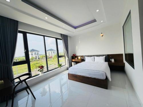 a bedroom with a bed and a large window at Hotel Trâm Anh 3 in Nhơn Trạch