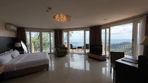 a bedroom with a bed and a balcony with a television at The Lake Hotel Tagaytay in Tagaytay