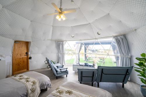 a bedroom with two beds and a ceiling fan at HOSHIとUmitoはサウナで整う完全プライベート1棟貸でプロジェクター完備 in Nakijin