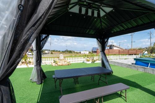 a tent with a bench in a yard at HOSHIとUmitoはサウナで整う完全プライベート1棟貸でプロジェクター完備 in Nakijin