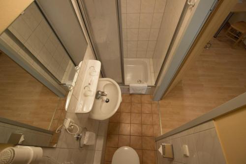 a small bathroom with a toilet and a shower at Hostel SLEPS in Augsburg