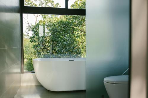 a large bath tub in a bathroom with a window at May Farm in Hương Hóa