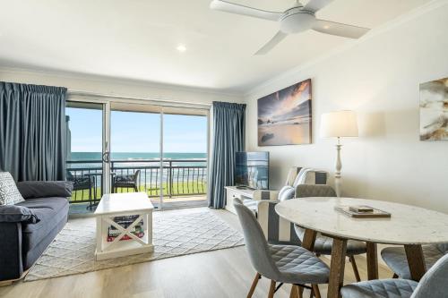 a living room with a couch and a table with a view at Apartment 9T in Lennox Head