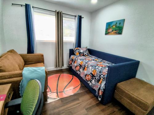 a living room with a bed and a chair at Miramar Retreat Arcade Game Room King Bed 25 Min to Hollywood Beach in Miramar