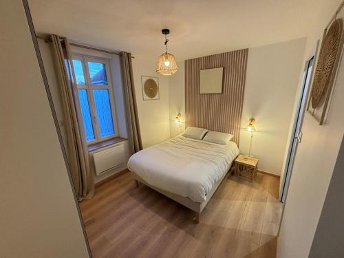 a bedroom with a white bed and a window at Le Cocon des Remparts in Gravelines