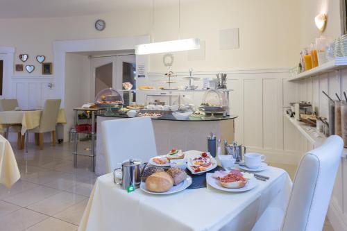 einen Tisch mit Teller mit Lebensmitteln in der Küche in der Unterkunft Hotel Atlantic Travemünde in Travemünde