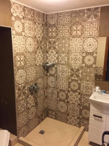 a bathroom with a shower with a tiled wall at City Garden Studio in Plovdiv