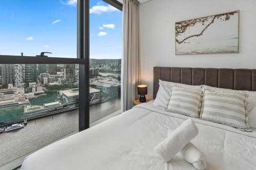a bedroom with a bed and a large window at 2B2B High Floor Apt with RiverView & Parking in Brisbane