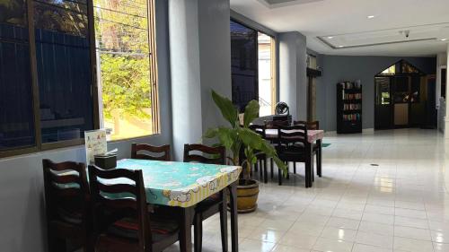 a dining room with a table and chairs and windows at Collection O Southern Star Resort Pattaya in North Pattaya