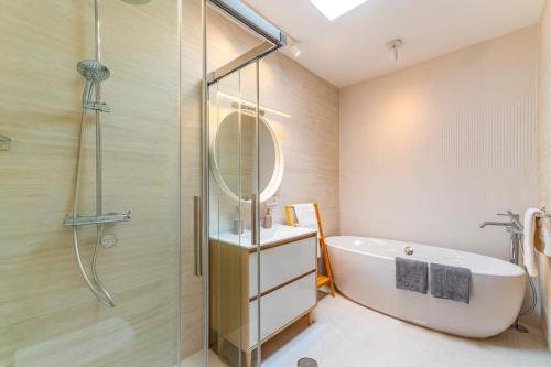 a bathroom with a shower and a tub and a sink at Villa Casa Luna by Villa Plus in Playa Blanca