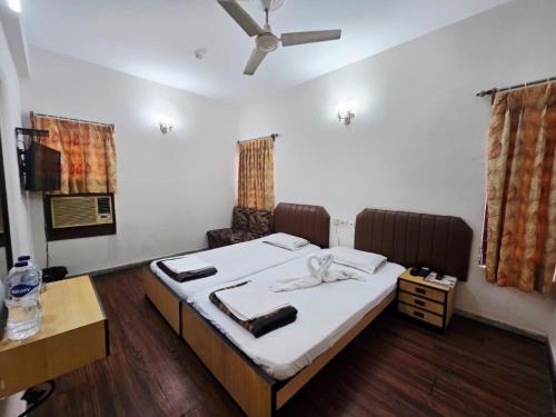 a bedroom with a large bed with white sheets at Hotel Akashdeep in Kolkata