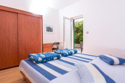 a bedroom with two beds with blue and white pillows at Apartments Ksenija in Stomorska