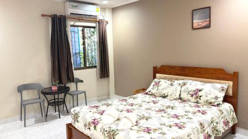 a bedroom with a bed and a table and a window at Collection O Southern Star Resort Pattaya in North Pattaya