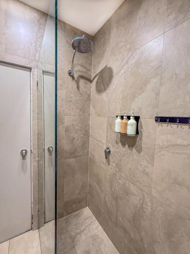 a bathroom with a shower with a glass door at Tequila Sunrise Potts Point in Sydney