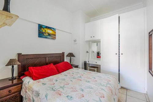 a bedroom with a bed with red pillows on it at Cabanas Del Mar 76 By Evermore in Kingsborough