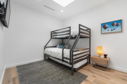 a bedroom with a black bunk bed with a lamp at Beachfront Bliss Luxury Views in Rye