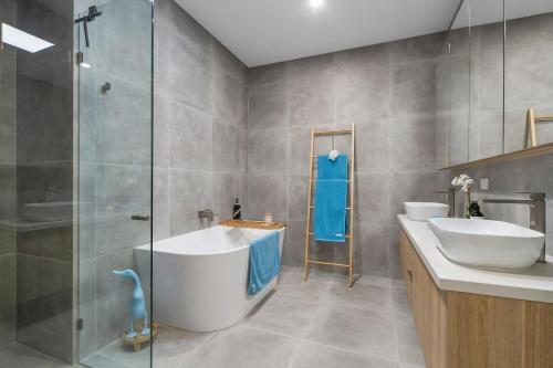 a bathroom with two sinks and a glass shower at Beachfront Bliss Luxury Views in Rye