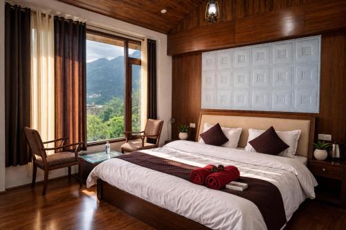 a bedroom with a large bed and a large window at Aura Montane luxury cottages in Manāli